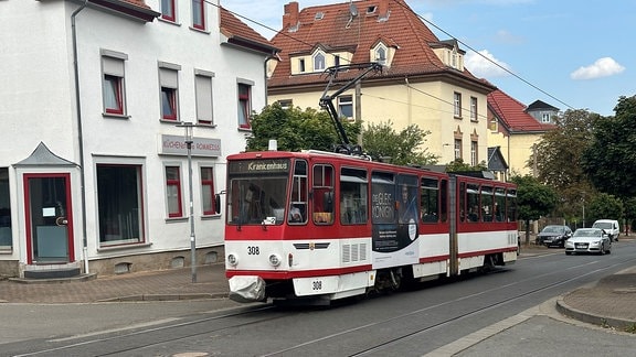 Eine rote Starßenbahn fährt durch Gotha