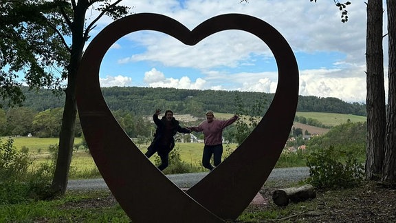 zwei springen in einem Herz aus Stahl in die Höhe