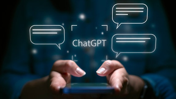 Chat-GPT-Schriftzug und Sprechblasen über Smartphone in den Händen einer Person