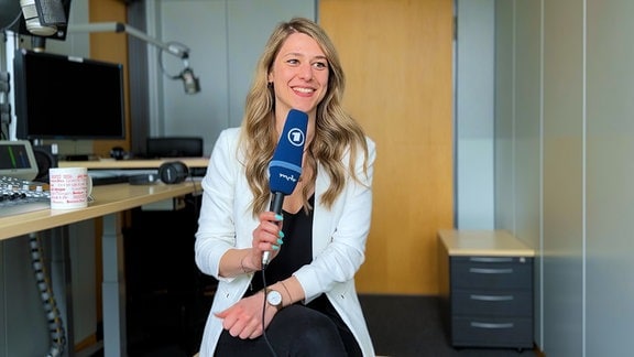 Die Volontärin Selina Uttecht auf einer schwarzen Couch im Foyer.