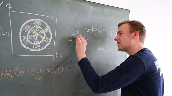 Merlin Füllgraf beim anzeichnen von Formeln: Dart - ein einfaches Spiel, aber mathematisch komplex.