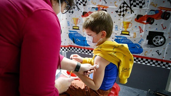 Ein Junge wird von einer Ärztin mit dem BioNTech/Pfizer-Kinder-Impfstoff geimpft.