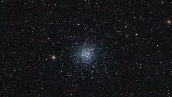 Dies ist eine Infrarotansicht des Kugelsternhaufens Messier 22, einer dicht gepackten Gruppe sehr alter Sterne, die sich etwa 10.000 Lichtjahre entfernt im Sternbild Schütze befindet. 