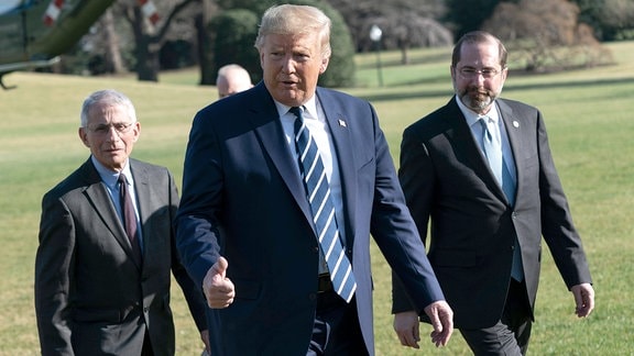 Donald J. Trump, Anthony Faucil und Alex Azarr treffen auf der Wiese vor dem Weisen Haus zuammen.