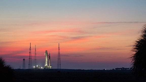 Rakete vor einem rot gefärbten Abendhimmel.