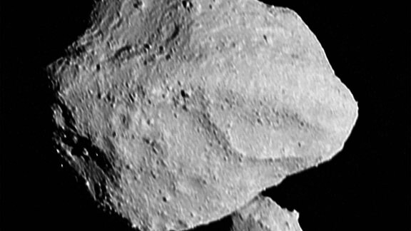 Dieses Bild zeigt den "Mondaufgang" des Satelliten, wie er hinter dem Asteroiden Dinkinesh auftaucht, wie er vom Lucy Long-Range Reconnaissance Imager (L'LORRI) gesehen wird. Es wurde um 16:55 (UTC) am 1. November 2023 aufgenommen, innerhalb einer Minute nach der größten Annäherung, aus einer Entfernung von etwa 430 Kilometern. Aus dieser Perspektive befindet sich der Satellit hinter dem primären Asteroiden. Das Bild wurde geschärft und bearbeitet, um den Kontrast zu erhöhen.