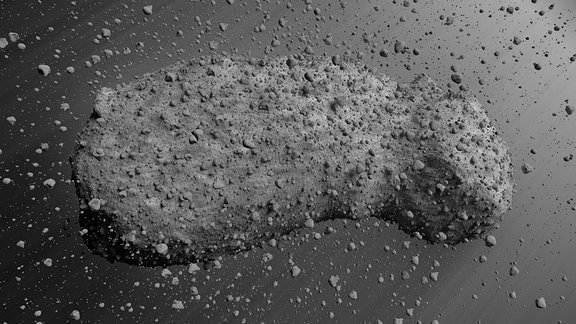 Künstlerische Darstellung des Asteroids Itokawa: Zu sehen oist ein länglicher grauer Felsen, der rund herum von zahlreichen frei schwebenden Steinen umgeben ist