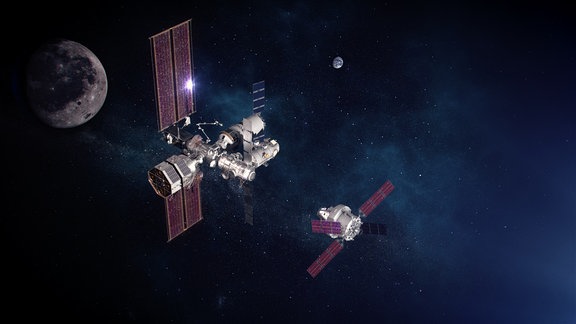 Eine dunkle künstlerische Weltraum-Darstellung des Lunar Gateway, einer Raumstation (mitte), die den Mond (links) umrunden soll. Von rechts kommt das Orion-Raumschiff angeflogen.