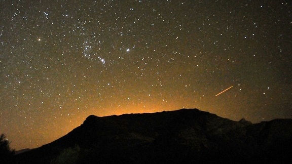 Ein Meteor streift über den Nachthimmel über der Geisterstadt Rhyolite in der Nähe von Las Vegas.