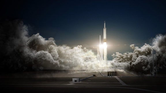 Ein Raketenstart der Trägerrakete Falcon Heavy vom privaten Raumfahrtunternehmen SpaceX. Die Rakete steigt mit viel Rauch auf. 