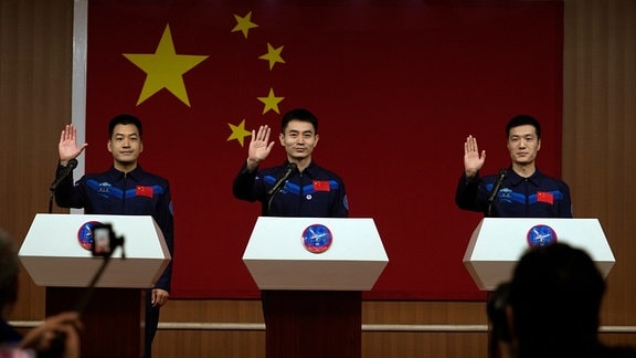 Die chinesischen Astronauten der bevorstehenden Shenzhou-18-Mission Li Guangsu (l-r), Ye Guangfu und Li Cong, winken, als sie zu einem Treffen mit der Presse im Jiuquan Satellite Launch Center ankommen.