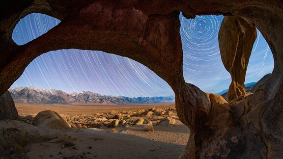 Kategorie: Himmelslandschaften  Kreise und Kurven © Sean Goebel  In diesem Stapel von 33 Vier-Minuten-Belichtungen kreisen die Sterne unter einem vierfachen Bogen um den Polarstern. Die kalifornische Sierra Nevada füllt den Horizont, und der Mount Whitney, der höchste Berg auf dem amerikanischen Festland, ist ganz links zu sehen.   Aufgenommen mit der Sony ILCE-7RIII Kamera, 12 mm f/2.8, ISO 2000, 33 x 4-Minuten-Belichtungen  Standort: Kalifornien, USA 