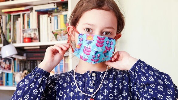 Die 5-jährige Lucia probiert beim Nähen von Mundschschutzmasken für den privaten Gebrauch eine Maske an.