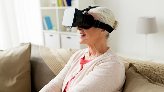 Eine Seniorin trägt eine VR-Brille