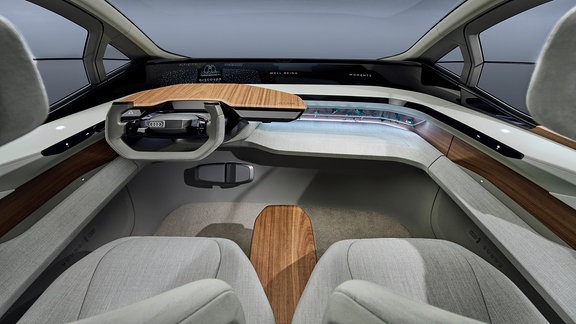  Visualisierung des Auto-Cockpits des Konzeptfahrzeugs Audi AI:ME (2019) mit einem futuristischen Design aus rauem Stoff und Holzelementen.
