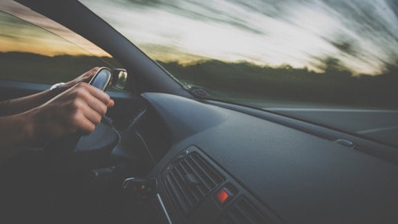 Hände eines Autofahrers an einem Lenkrad