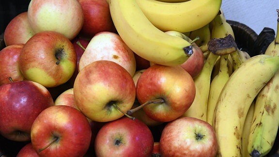 Äpfel und Bananen in einem Obstkorb.