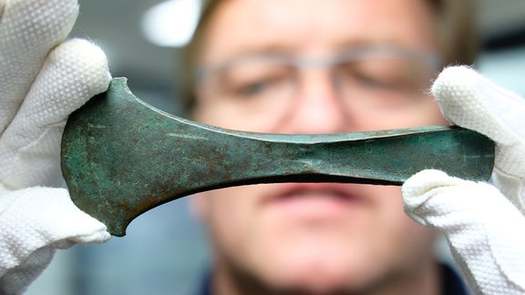 Archäologe Roman Mischker vom Landesamt für Denkmalpflege und Archäologie Sachsen-Anhalt mit Beil-Klinge aus früher Bronzezeit
