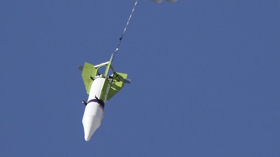Eine Rakete landet mit Fallschirm