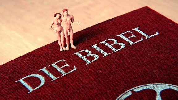 Adam und Eva auf einer Bibel