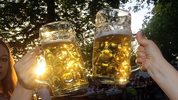 Zuprosten mit zwei Maßkrügen Bier in der Abendsonne