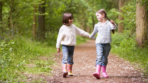 Zwei Mädchen spazieren durch den Wald.
