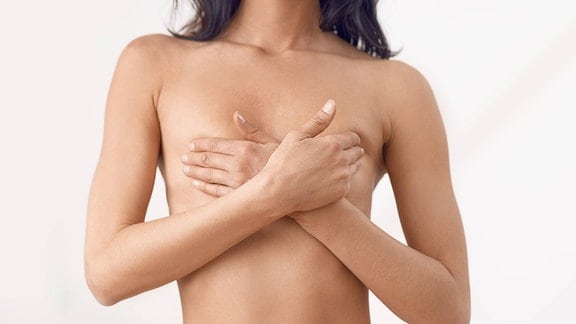 Frau bedeckt Brüste mit Händen