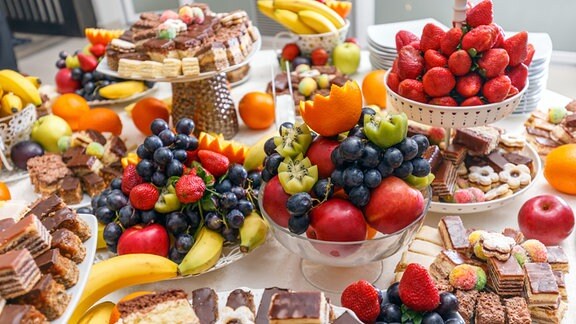 ein Tisch voll mit Obst und Kuchen