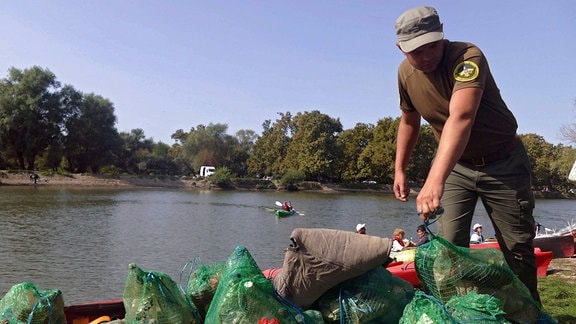Netzsäcke mit Müll, die aus dem Turunchuk-Fluss gefischt wurden, werden während der großen Reinigungsaktion an den Flussufern der Region Odessa.