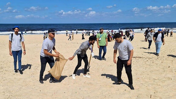 Palästinenser beteiligen sich an der Säuberung der Strände entlang der Mittelmeerküste während der EU-Strandsäuberungskampagne in Gaza Stadt