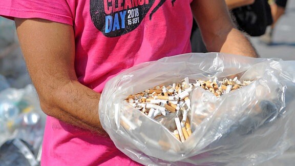 An einem Strand in Italien hat ein Mann einen Beutel voll Zigarettenstumpen aufgesammelt. 2020