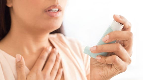Frau verwendet Asthmaspray