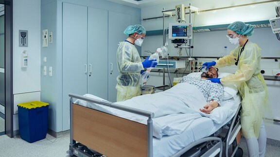 Ein Intensivstationsbett mit einem Patienten und Ärzten