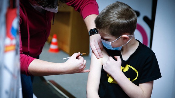 Ein Junge wird von einer Ärztin mit dem BioNTech/Pfizer Kinder Impfstoff geimpft.