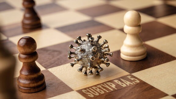 Omikron-Modell auf einem Schachbrett mit Schachfiguren
