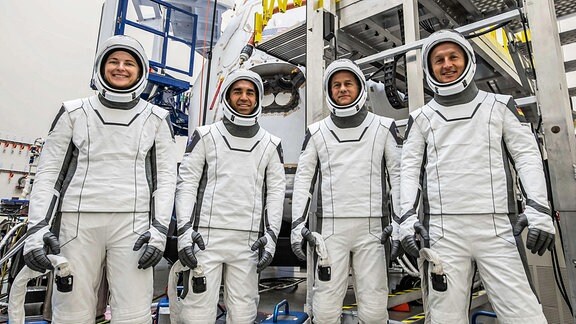 Die Crew-3-Mission - eine Astronautin und drei Astronauten in Raumanzügen