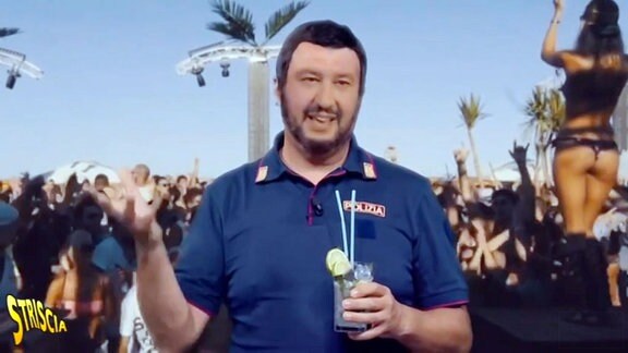 Ein Mann mit einem Getränk in der Hand steht vor einer Palme.