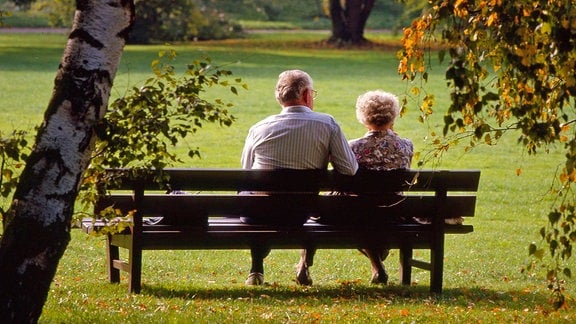 Ein älteres Paar sitzt auf einer Parkbank