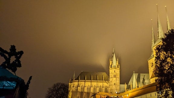 Erfurter Dom wird bei Nacht so ineffizient angestrahlt, dass ein Teil des Lichts in die Wolken fällt, auf die Gebäude sichtbare Schatten werfen.