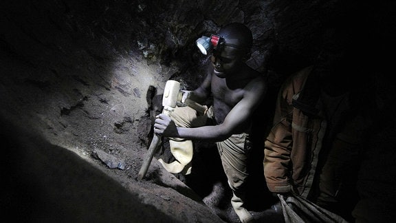 Bauxitabbau in Kongo. Ein Minenarbeiter mit Presslufthammer arbeitet unter Tage.