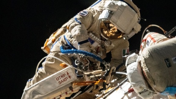 Die ESA-Astronautin Samantha Cristoforetti bei ihrem allerersten Weltraumspaziergang an der Seite des Kosmonauten Oleg Artemyev. Dieser Weltraumspaziergang war auch der erste einer europäischen Frau. Die beiden Weltraumspaziergänger haben während ihrer siebenstündigen Außenbordtätigkeit eine Reihe von Aufgaben erledigt. Sie setzten zum Beispiel im Rahmen eines Funktechnologie-Experiments zehn Nanosatelliten von Hand aus.