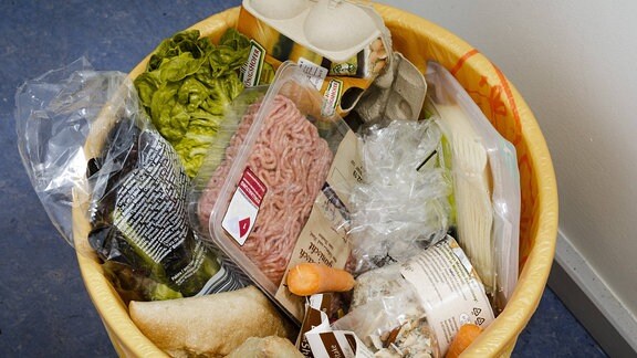 Lebensmittel liegen in einem Mülleimer.