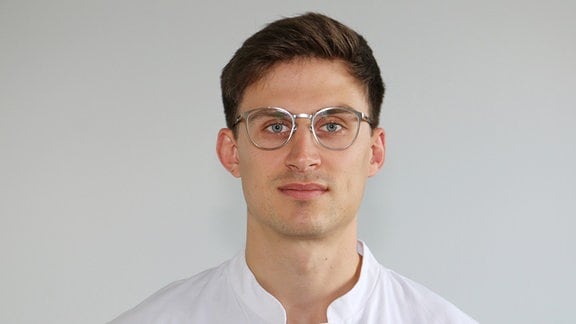 Junger Mann in weißem Hemd mit Brille 