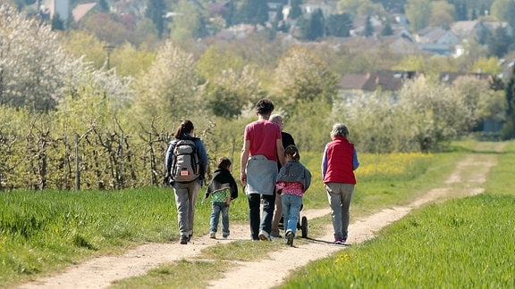 Familie mit Kindern unterwegs auf einem Feldweg