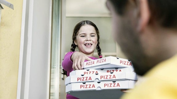 übergewichtiges Mädchen mit Pizzaschachteln