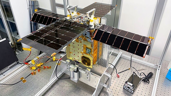 Der Cubesat Lunar Flashlight ist gerade einmal so groß wie ein Aktenkoffer. Auf diesem Bild befindet der solarbetriebene Kleinsatellit sich mit ausgefahrenen Solarzellen in einem Reinraum der Georgia Tech (USA). | Bildrechte: NASA, JPL-Caltech Der Cubesat Lunar Flashlight ist gerade einmal so groß wie ein Aktenkoffer. Auf diesem Bild befindet der solarbetriebene Kleinsatellit sich mit ausgefahrenen Solarzellen in einem Reinraum der Georgia Tech (USA).