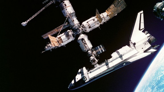 Das amerikanische Space Shuttle Atlantis dockt an die russische Raumstation MIR im Juni 1995 an. Die Kooperation zwischen beiden Nationen nimmt ihren Anfang. Wenige Jahre später folgt der Bau der Internationalen Raumstation ISS