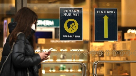 An der Eingangstür eines Geschäfts in der Hamburger Innenstadt weist ein Aufkleber auf die FFP2-Maskenpflicht im Einzelhandel hin.