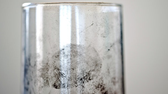 Spurensicherungspulver: Schwarze Fingerabdrücke auf einem Glas