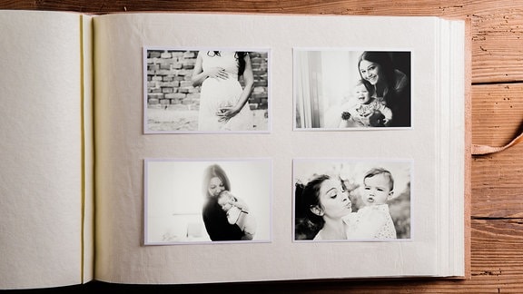 Fotoalbum mit Schwarz-Weiß-Fotos, die eine schwangere Frau und eine Frau mit Baby zeigen